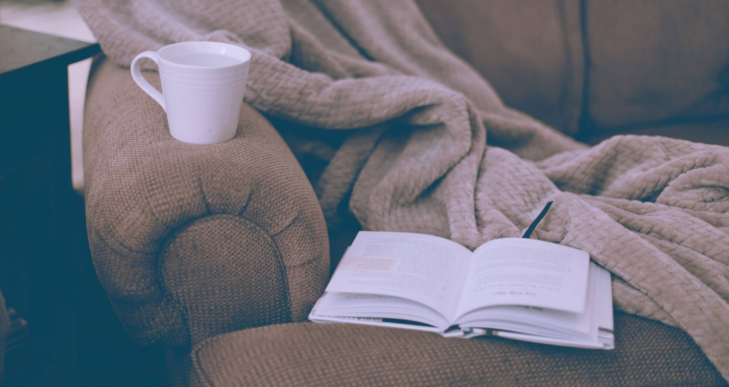 chair with blanket, book, and mug