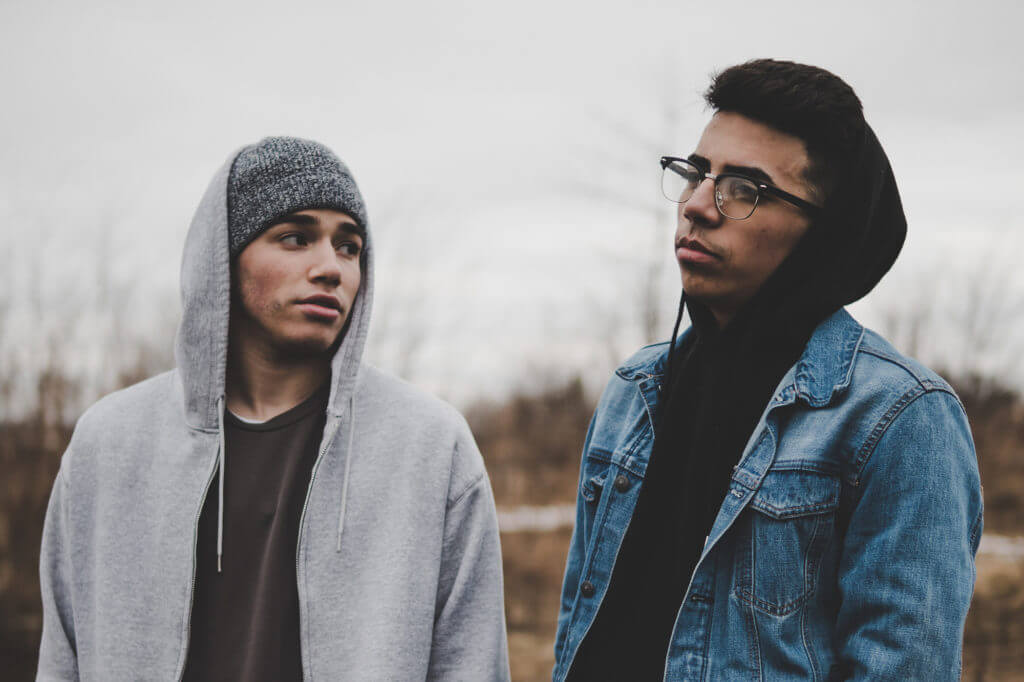 Two young men standing in a field.