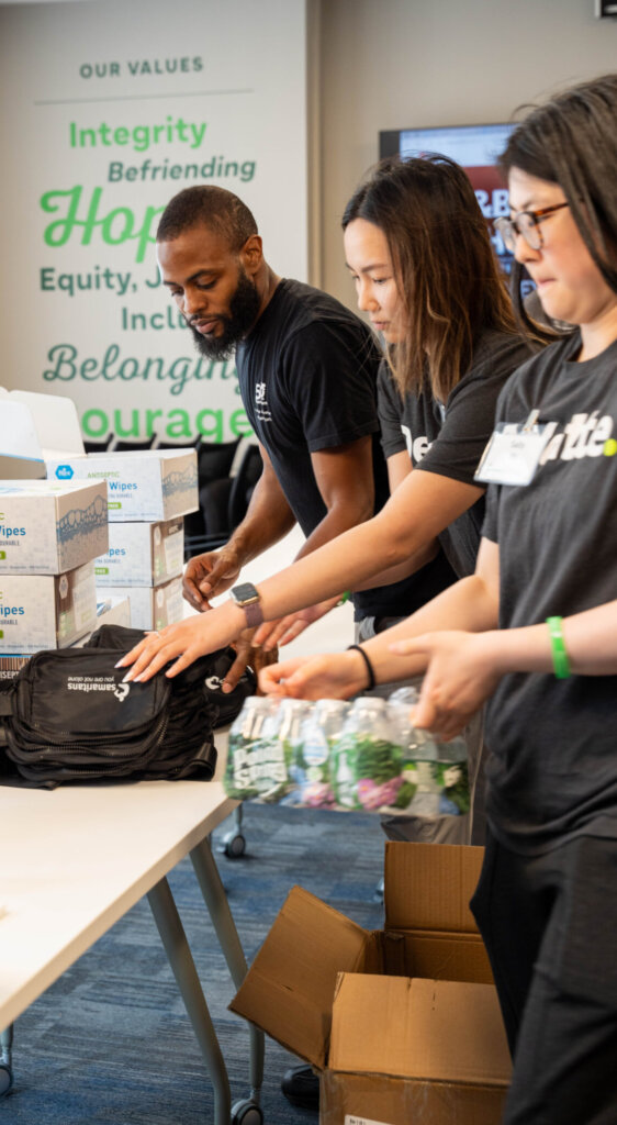 Michael Davis and Deloitte volunteers assemble Basic Needs kits.