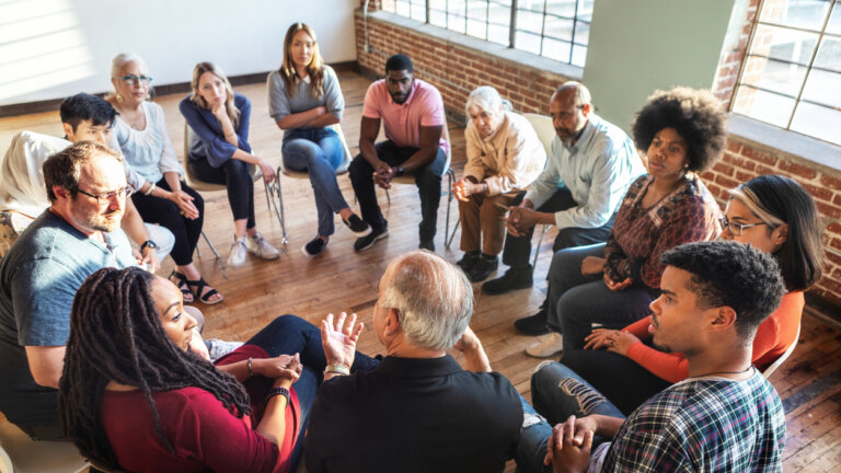 Group of people sitting in a circle in a support group.