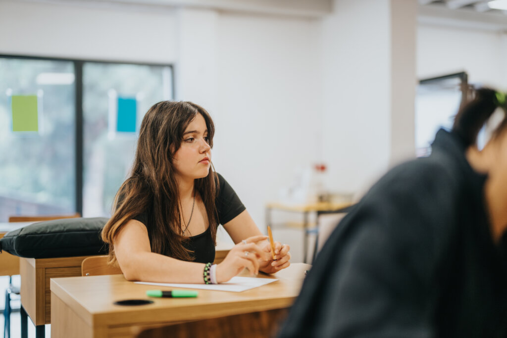 A student struggling with suicidal thoughts sitting at her desk in class