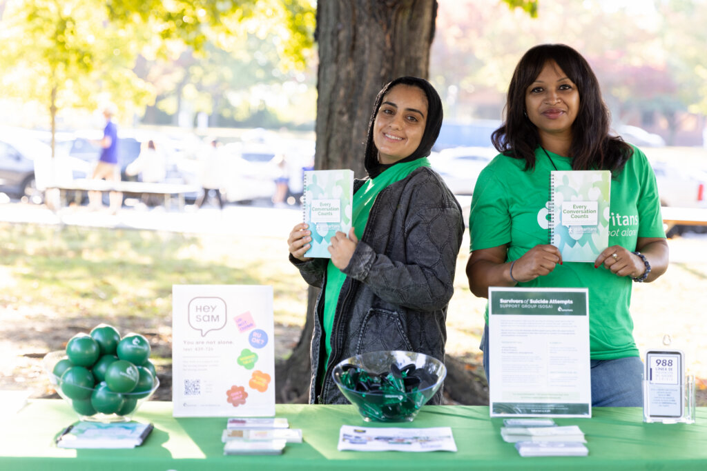 Two women holding Samaritans notebooks at the 2025 Samaritans 5k.